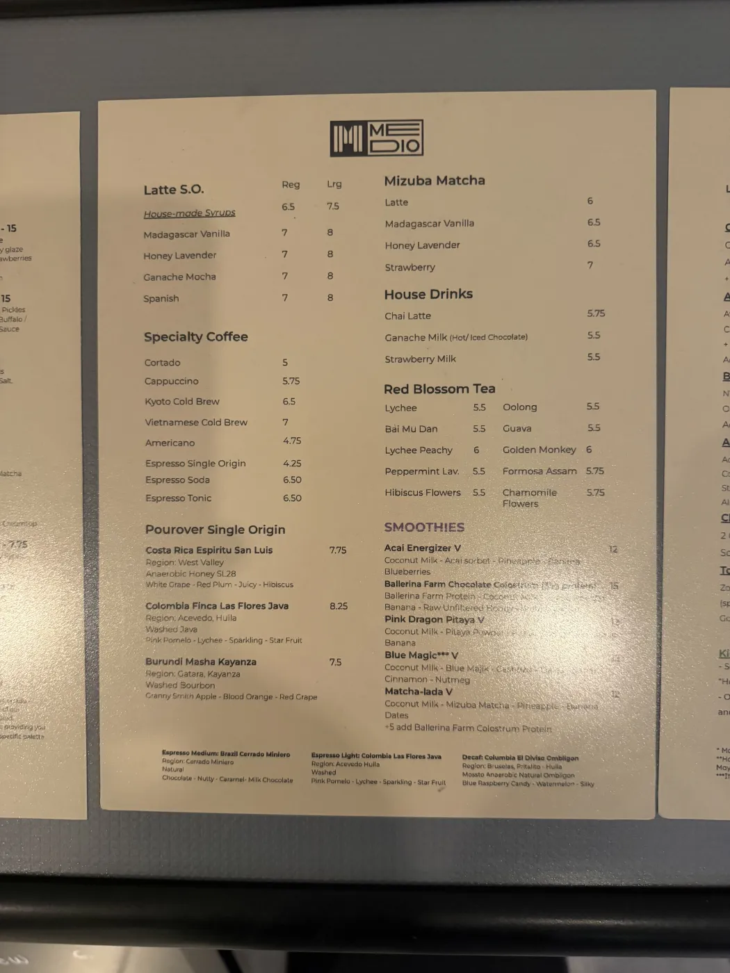 Medio Cafe's printed menu, showing three pour-over single origins: Costa Rica Espiritu San Luis, Colombia Finca Las Flores Java from Acevedo Huila with pink pomelo, lychee, sparkling and star fruit, and Burundi Masha Kayanza, alongside espresso drinks, Mizuba matcha, and Red Blossom teas.